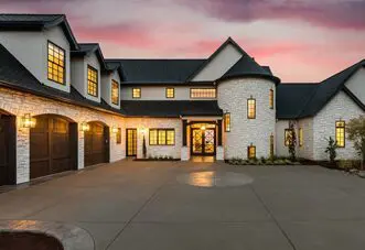 A large white house with two garage doors.