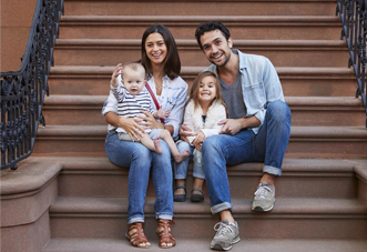 A family sitting on the steps of their home.