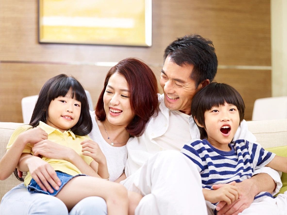 A family sitting on the couch with two children.